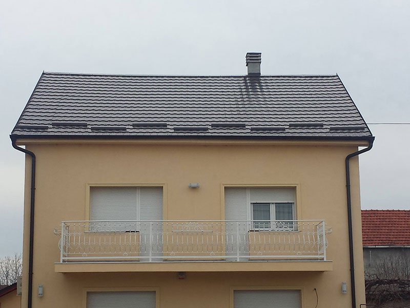 Porodična kuća sa tamnosivim krovom od lima u obliku crepa
