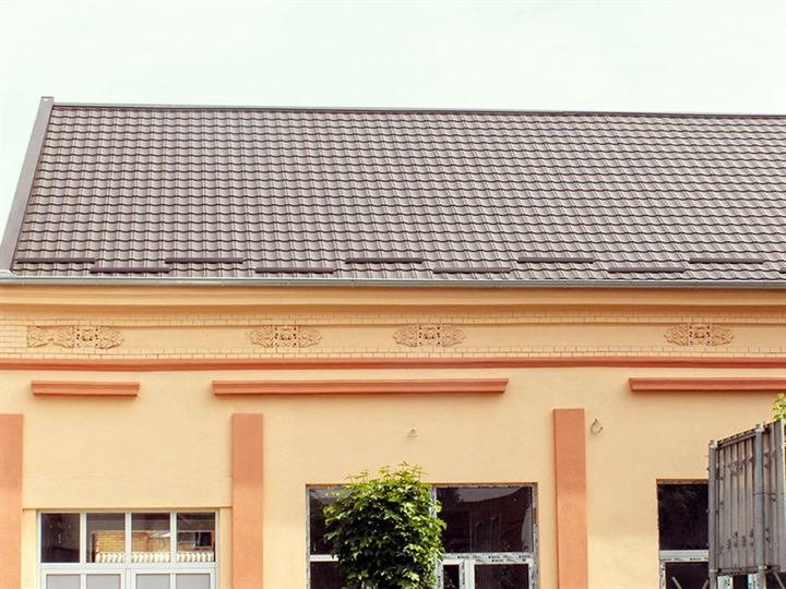Starija kuća sa novim sivim krovom od lima u obliku crepa